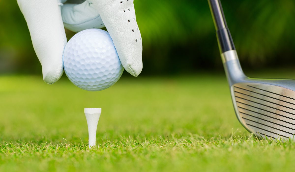 Close up view of golf ball on tee on golf course